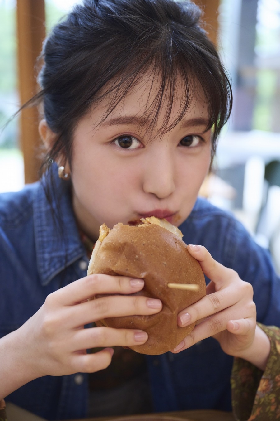 写真はハンバーガーにかじりつく福本さん　撮影：土山大輔／講談社